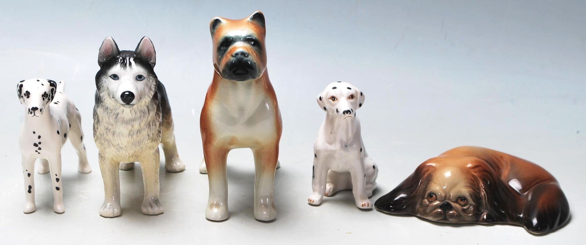 A collection of 20th Century ceramic figurines of dogs in various shapes and sizes to include a