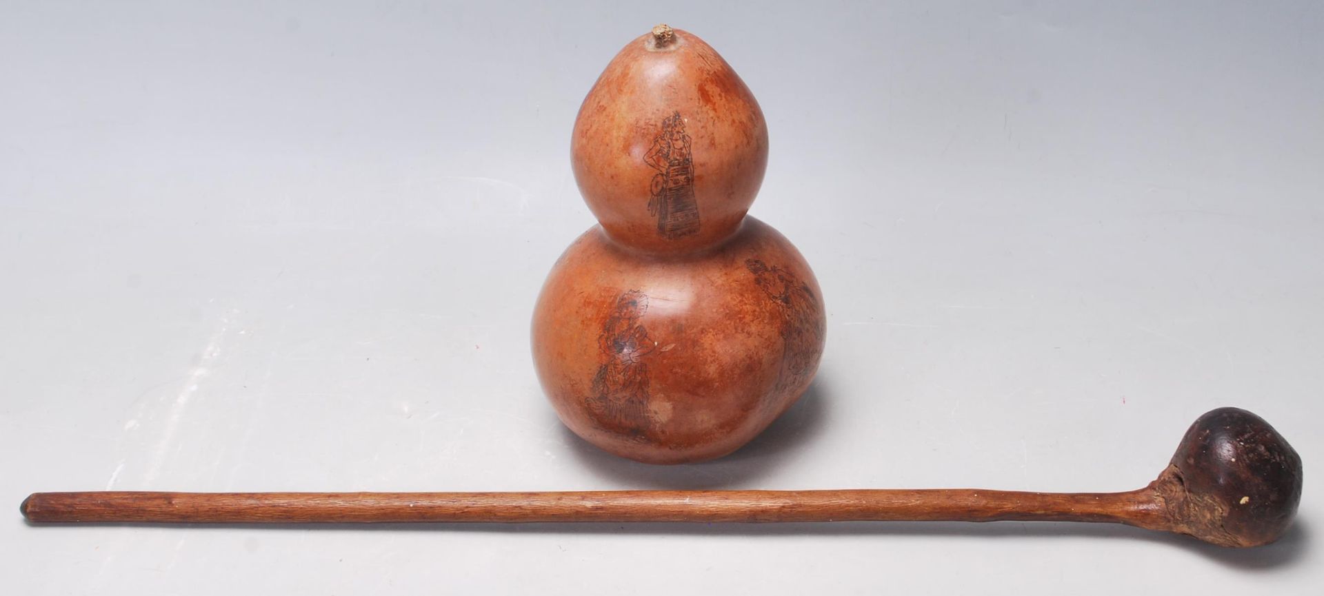 An early 20th century tribal hand carved Knobkerrie weapon along with a double gourd vase with