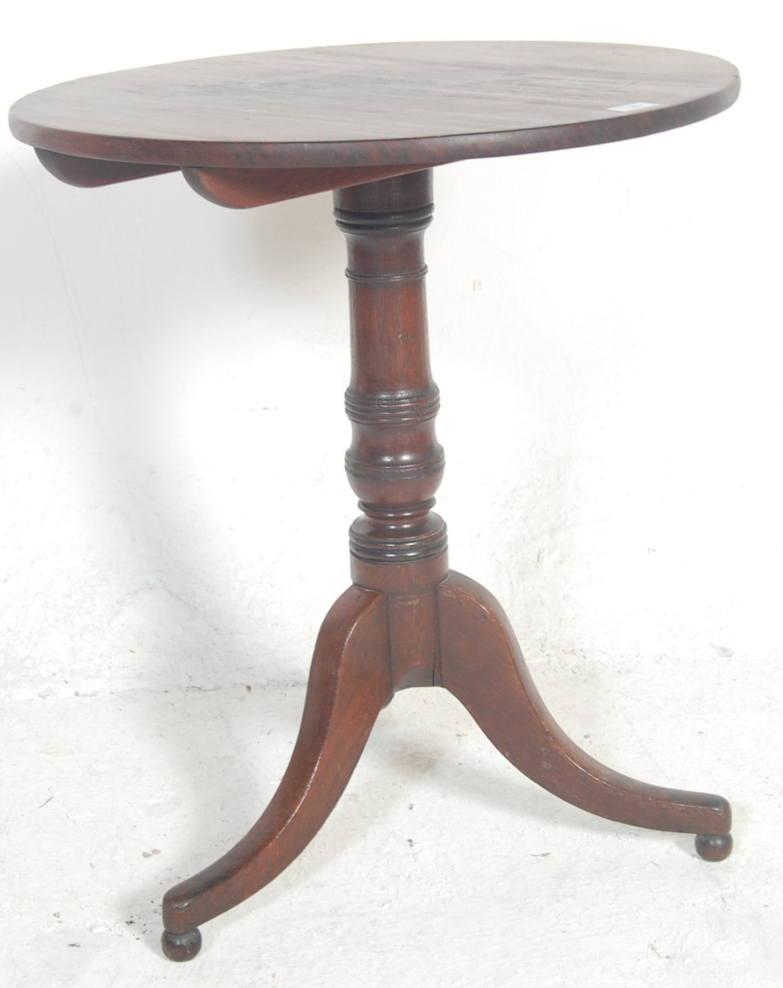 A Victorian 19th century mahogany tilt top wine / occasional table being raised on splayed leg