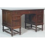 A 1920's Jacobean oak revival twin pedestal partners desk. Raised on turned legs with peripheral