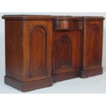A Victorian 19th century inverted breakfront mahogany sideboard – credenza being raised on a