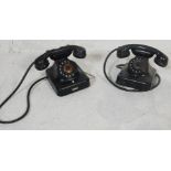A pair of early 20th century Bakelite telephones in black. Each with ring dials with white numbers