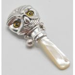 A silver babies / childs rattle in the form of an owl with yellow and black glass eyes having a
