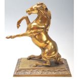 A vintage 20th century brass horse mantle ornament sitting on the back legs with front legs