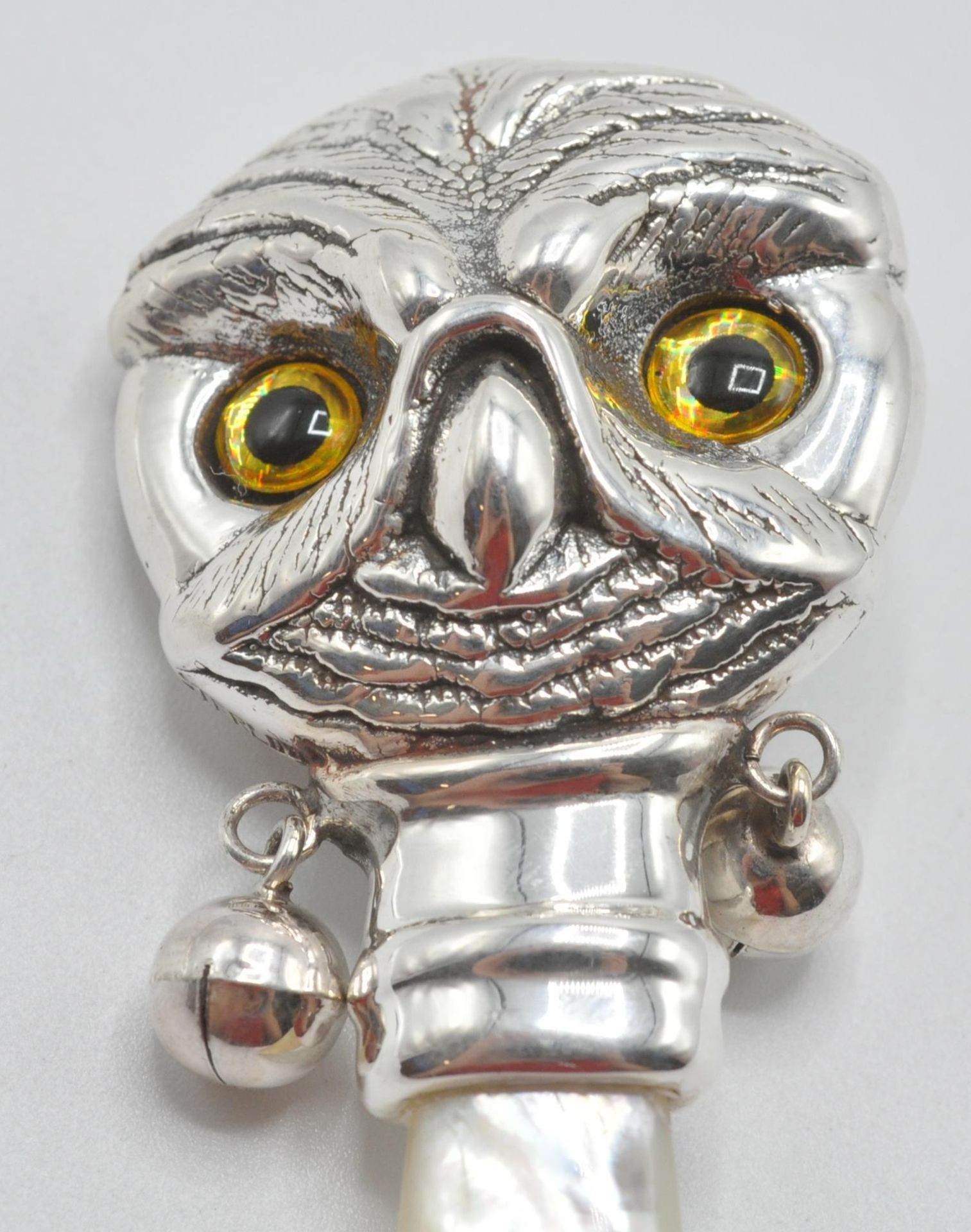 A silver babies / childs rattle in the form of an owl with yellow and black glass eyes having a - Bild 2 aus 6