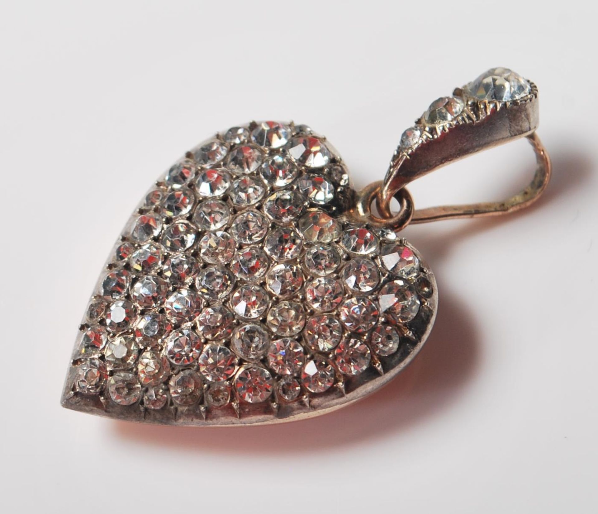 A 20th Century silver and paste stone set pendant in the form of a heart having a paste set bale and