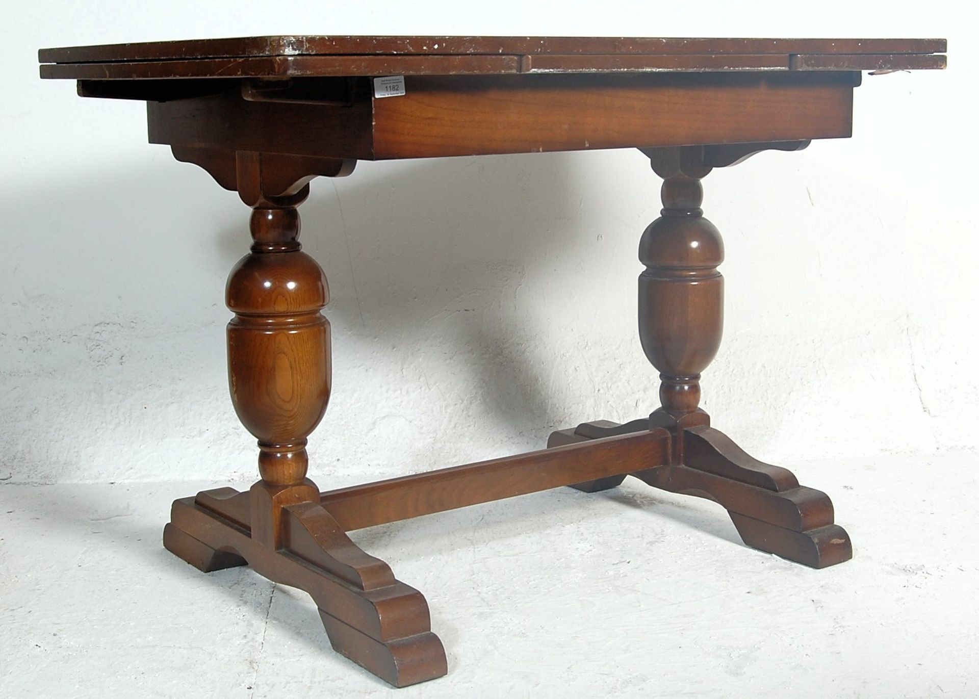 A vintage 1920s early 20th Century oak draw leaf dining table. The table having a panelled oak