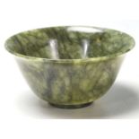 A 20th Century Chinese carved green stone footed bowl of small proportions having a flared rim.