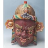 A 20th Century Chinese Tibetan carved wooden wall mounting mask in the form of a demon / mythical