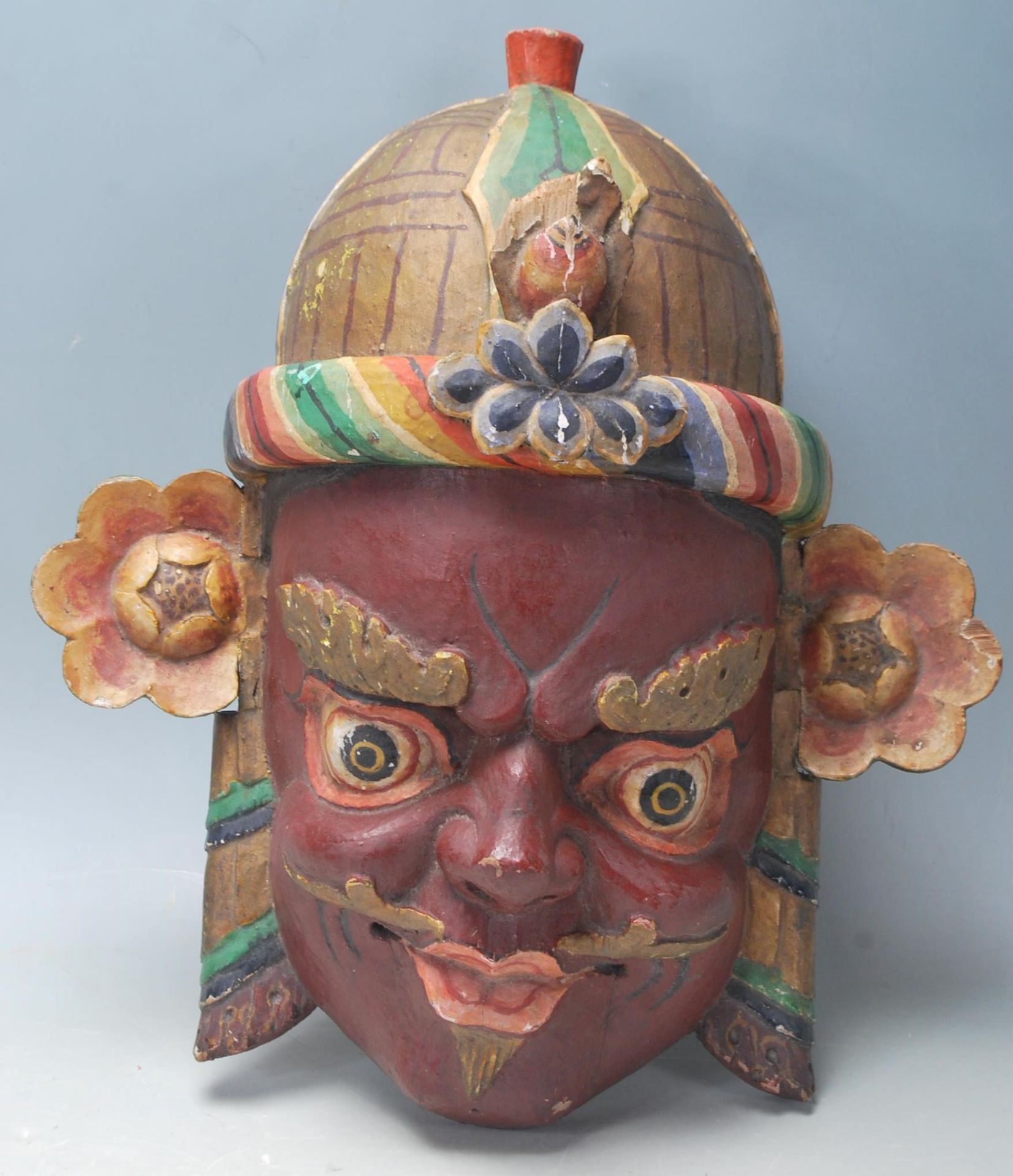 A 20th Century Chinese Tibetan carved wooden wall mounting mask in the form of a demon / mythical