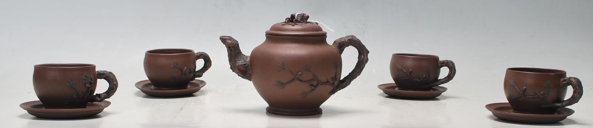 A 20th century Chinese yi xing terracotta teapot, cups and saucers having a handle and spout in