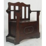 A 1920's carved oak Jacobean revival hall settle bench / stick stand combination. Raised on