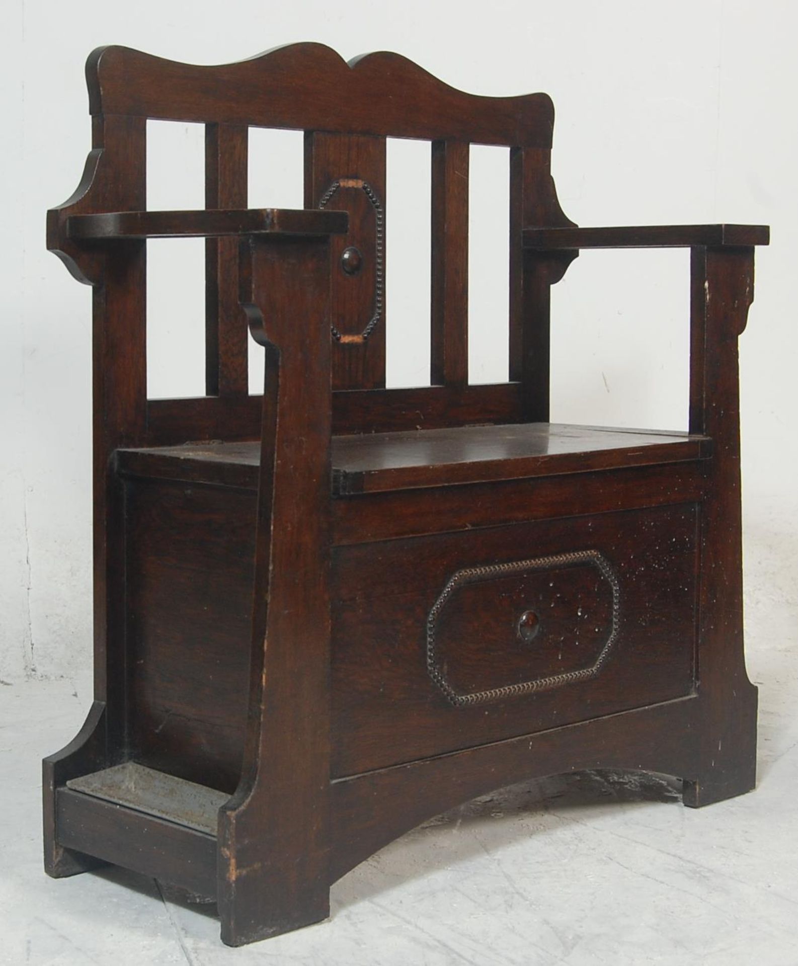 A 1920's carved oak Jacobean revival hall settle bench / stick stand combination. Raised on