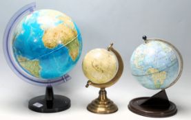 A group of three retro vintage 20th Century desktop globes to include a mid Century globe raised