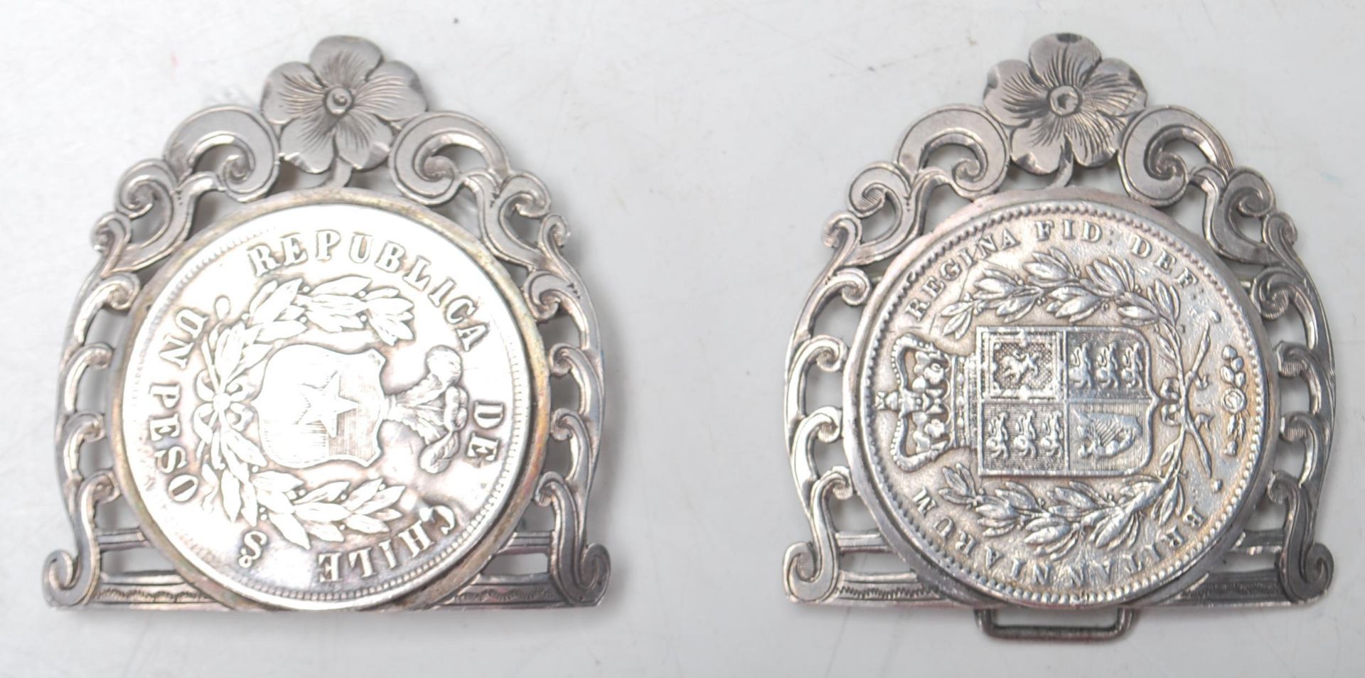An antique belt buckle having two 19th Century silver coins moulded to the front panel and decorated