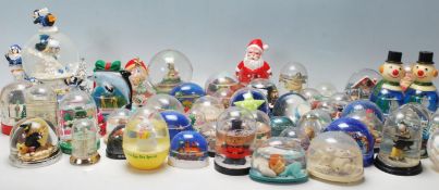 A large collection of original vintage collectable plastic snow globes from around the world to