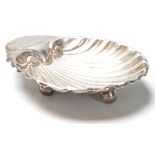 A silver hallmarked Daniel George Collins trinket dish in the form of a scallop shell raised on