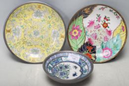 A collection of three mid 20th century Chinese pewter and ceramic plates. The collection comprises