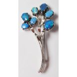 A mid 20th Century silver floral spray brooch being set with seven oval opal doublets in prong