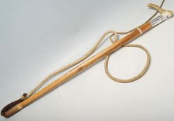 A 20th Century vintage whip having a wooden bone handle over a silver collar decorated with a