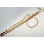 A 20th Century vintage whip having a wooden bone handle over a silver collar decorated with a