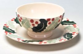 A late 20th Century ceramic tea cup and saucer by Emma Bridgewater in the Holly pattern decorated in