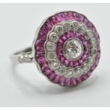 A platinum ruby and diamond cocktail ring. The ring having a round head with a central brilliant cut
