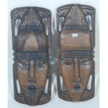 A pair of 20th century African tribal wooden  wall plaque / face mask having hand carved