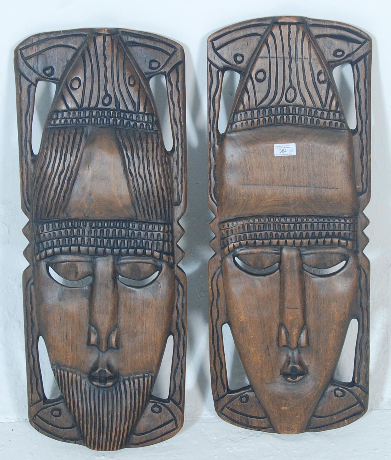 A pair of 20th century African tribal wooden  wall plaque / face mask having hand carved