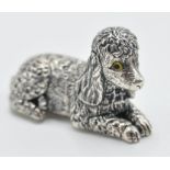 A sterling silver figurine of a poodle dog in a si