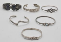 A group of silver bangle bracelets to include a bu