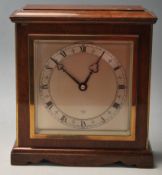 An mid century 1960s Oak mantle clock having a ped