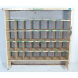 A vintage mid 20th century metal industrial wall hanging pigeon hole shelf having graduated holes