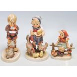 A group of German W. Goebel ceramic figurines to include a girl feeding the chickens, a boy and