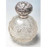 A Edwardian, 1903 silver hallmarked and cut glass perfume bottle having an embossed foliate design