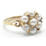 A vintage 9ct gold ladies ring being set with a cluster of seven pearls to the head with pierced and
