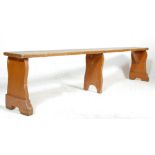 An early 20th century antique church bench / pew having three gate legs and plain seat rest.