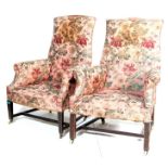 A pair of 19th century Victorian armchairs having oak squared tapered supports united by