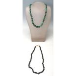 A 20th Century Chinese green hard stone beaded necklace having round green beads with a yellow metal