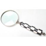 A LARGE BLACK AND WHITE CHEQUERED HAND HELD MAGNIFYING GLASS