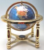 A small 20th Century desk top ornamental blue terrestrial globe raised on a brass gimbal stand