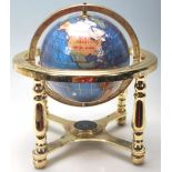 A small 20th Century desk top ornamental blue terrestrial globe raised on a brass gimbal stand