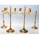 A SET OF FOUR BRASS CANDLESTICKS.