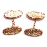 A pair of 9ct gold gentleman's cufflinks having oval heads with engraved foliate decoration united