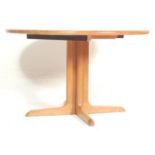 A vintage late 20th century teak wood danish inspired circular extendable dining table having