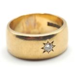 A hallmarked 9ct gold band ring being set with a round cut white stone in a star setting. Hallmarked