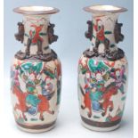 A pair of early 20th Century Chinese ceramic vases having a flared top with twin handles over hand