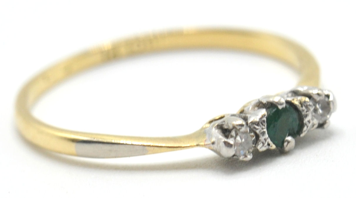 A hallmarked 18ct gold and platinum ring set with a green central stone flanked by 2 white stones.