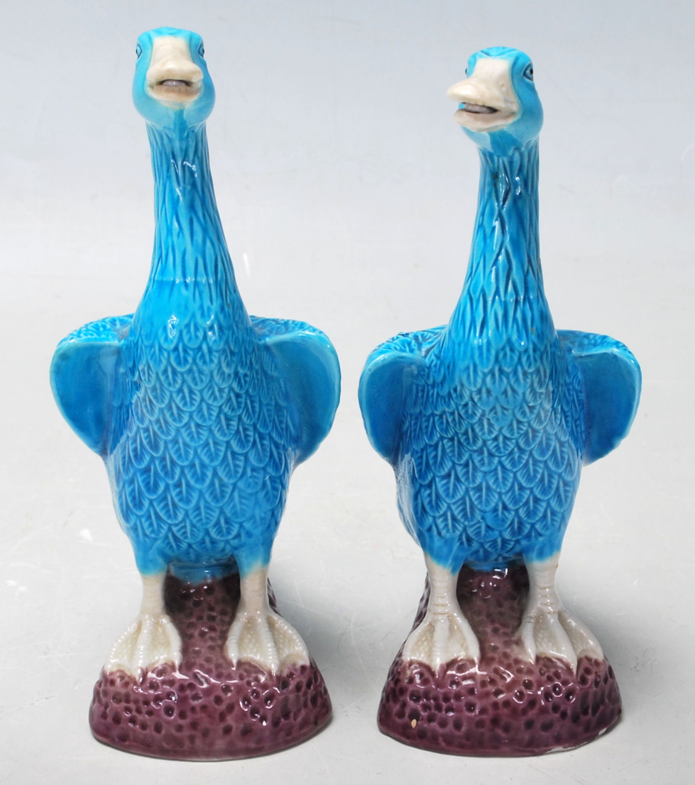 A pair of vintage turquoise blue Japanese ducks figurines having white opened beak, opened wings,