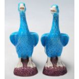 A pair of vintage turquoise blue Japanese ducks figurines having white opened beak, opened wings,